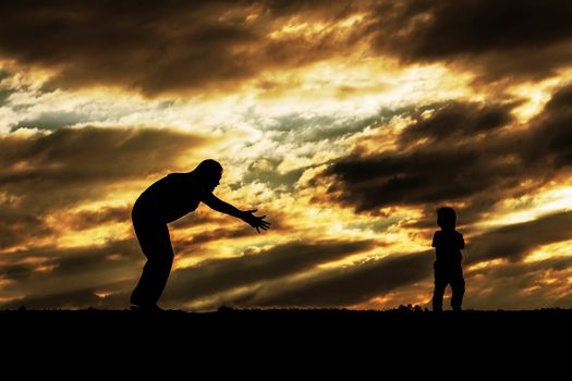 Mother and son are playing with the sky at sunset.