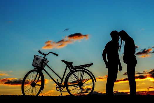 Young of love and biking at the sunset.