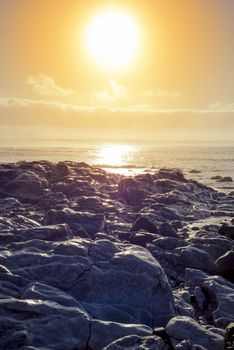 beautiful soft waves break on the rocks on sunset ballybunion beach in ireland