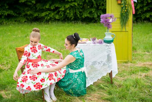 mother with daughter have a breakfast in the garden