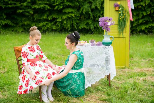 mother with daughter have a breakfast in the garden