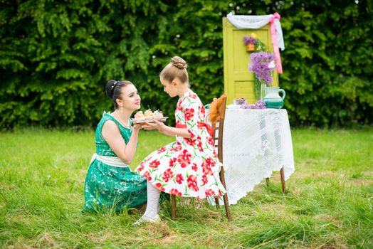 mother with daughter have a breakfast in the garden