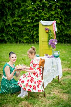 mother with daughter have a breakfast in the garden