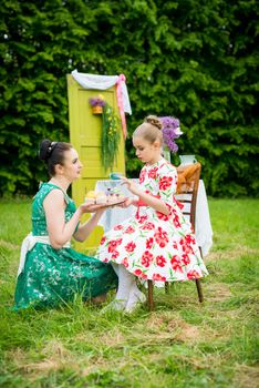 mother with daughter have a breakfast in the garden