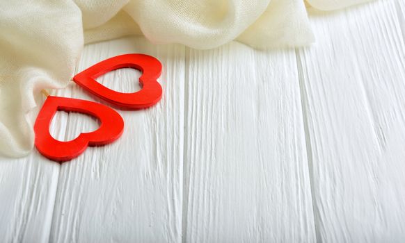 White background with two red hearts and a scarf for a congratulation Happy Valentine's Day. Copy space,top view