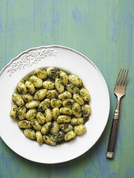 close up of rustic italian gnocchi in pesto sauce