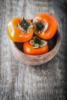 Fresh sweet Persimmons on a wooden table