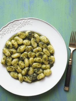 close up of rustic italian gnocchi in pesto sauce