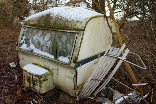 Old Vintage Dirty Abandoned Camper Camping Wagon Caravan  in a small forest                              