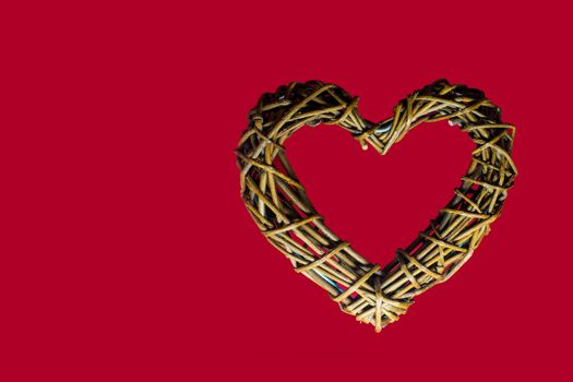 Wooden heart in a red background, symbol of love