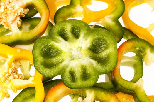 slices of yellow and green pepper vegatebles on white background.