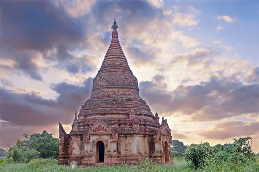 Ancient pagoda in the landscape from Bagan in Myanmar at sunrise