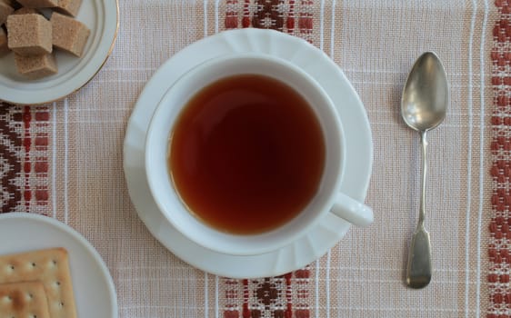 cup with tea on a beautiful tablecloth top view