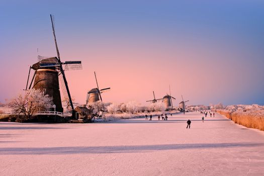 Ice skating at Kinderdijk in the Netherlands at sunset
