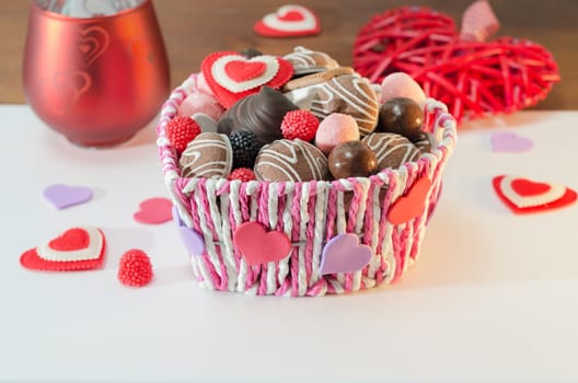 Sweets, biscuits and decorative hearts for Valentine's day in the basket. Selective focus.