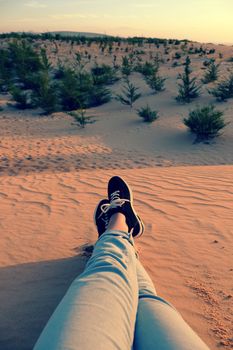 Summertime background with woman foot on sand hill, people relax on orange sandy under blue sky at Mui Ne, Phan Thiet, Vietnam, summer is coming and a trip to adventure make awesome life 