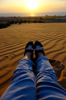 Summertime background with woman foot on sand hill, people relax on orange sandy under blue sky at Mui Ne, Phan Thiet, Vietnam, summer is coming and a trip to adventure make awesome life 