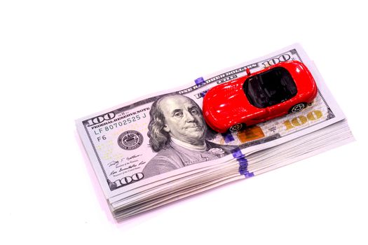 One hundred dollars banknotes and a red sports car
