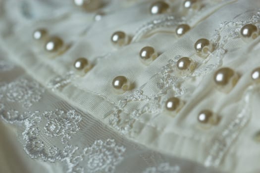 textile wedding background with beads. Tiny pearls embroidered over a wedding dress