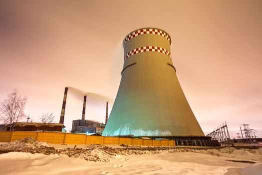 Thermal power plant and cooling towers at night near the city