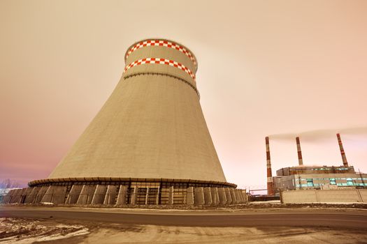 Power plant and cooling towers at dusk near the city