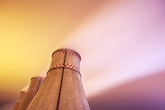 Cooling towers of power plant at night. Smoke in the sky