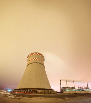 Thermal power plant and cooling towers at night near the city