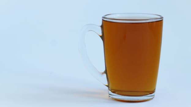 Full transparent glass poured milk on light white and blue background