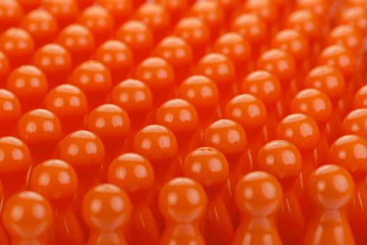 Conceptual orange game pawns as abstract view of a crowd
