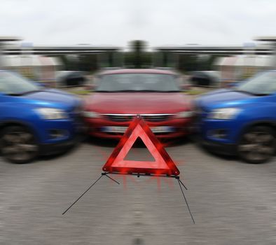 Three vehicles after a car accident. In the foreground a warning triangle.