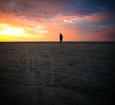 Silhouette of man looking the sunset beach.