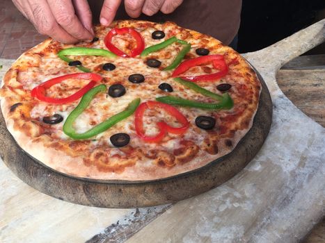 Closeup of hands making pizza. Cooking Pizza on wooden backgroun .