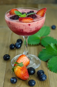 Raspberry smoothie with fresh berries on a wooden table