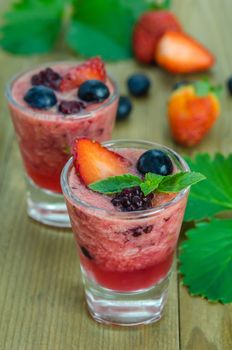 Raspberry smoothie with fresh berries on a wooden table