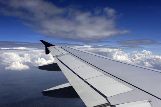 Wing of the plane on a background of clouds