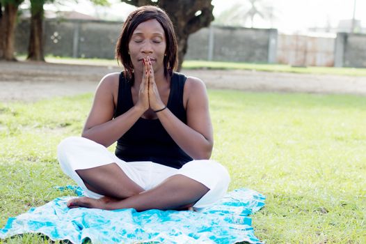 This young woman sitting in the shade of a tree is in full meditation.