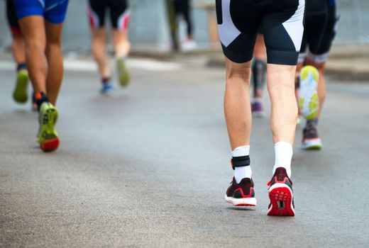 Group of marathon runners on the street. Back view.