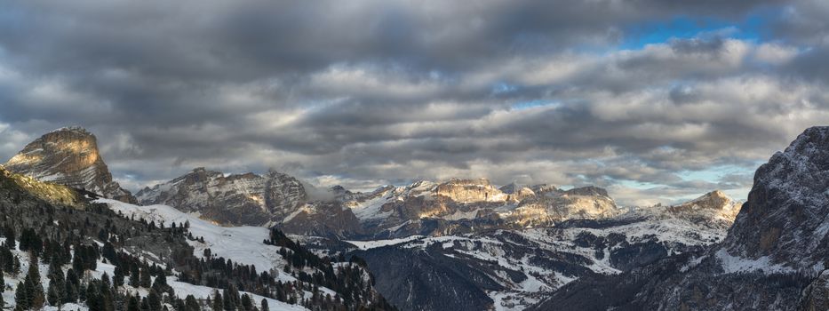 Sunset over mountains of Alta Badia in a winter end of the day with cloudy sky , Dolomites
