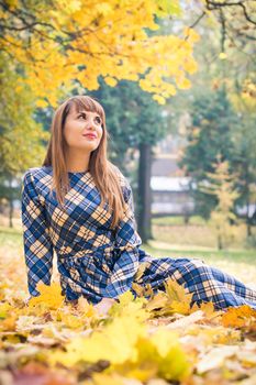 beautiful, dreamy girl with long straight hair in a blue long dress in the park in autumn