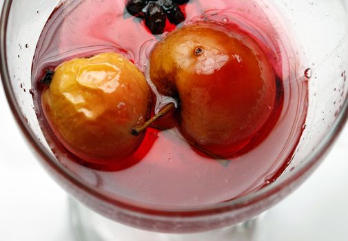 Red apple in rose syrup with anise over isolated white background