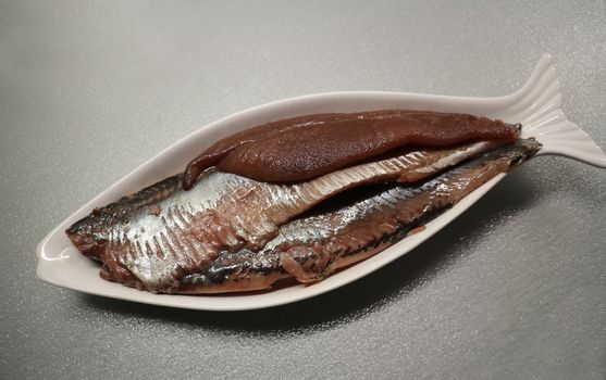 salted herring with caviar on a plate closeup