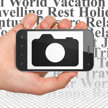 Vacation concept: Hand Holding Smartphone with  black Photo Camera icon on display,  Tag Cloud background, 3D rendering