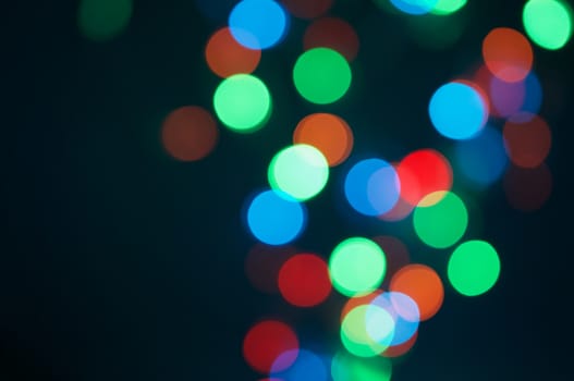 Colorful bokeh circle or defocused of glitter on right side at night as background.