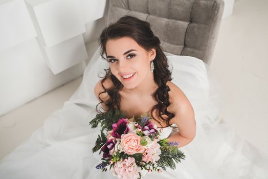 Beautiful bride posing in her wedding day with flower bouquet