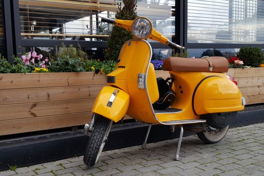 Chalkida, Greece - February 11, 2017: Yellow  scooter parked in a town Chalkida, Greece