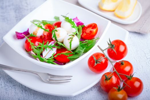 Fresh mozzarella balls served with spicy rocket leaves and cherry tomatoes.