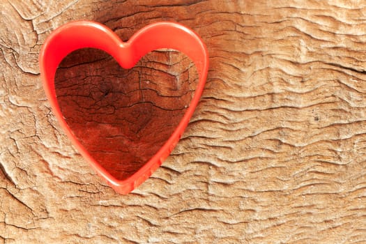 Idea for card Valentine day. Heart shaped cookie cutter on old wood background