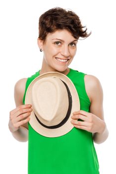 cute brunette in a green top, holding a hat on a white background isolated