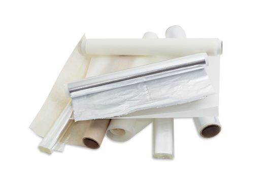 Several rolls of the plastic oven bags, plastic food wrap, aluminum foil and various parchment paper for household use on a light background. 
