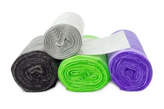 Several plastic disposable garbage bags of different sizes and colors in rolls including biodegradable, closeup on a light background
